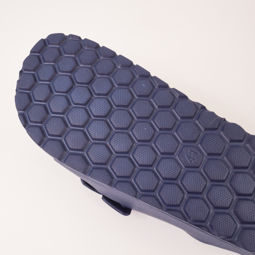 A imagem mostra os detalhes do solado da sandália ortopédica Ergonofeet, na cor azul marinho