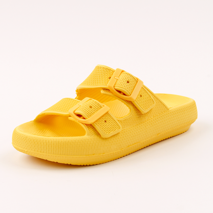 Sandália ortopédica feita em EVA expandido na cor amarela, com fivelas para ajuste. Possui solado espesso de quase 4 cm, que distribui o peso dos pés, alivia pontos de pressão e oferece conforto e estabilidade ao caminhar. Indicada para dores nos pés, como esporão de calcâneo e fascite plantar. Conta com bordas laterais elevadas, solado antiderrapante e tiras macias.
