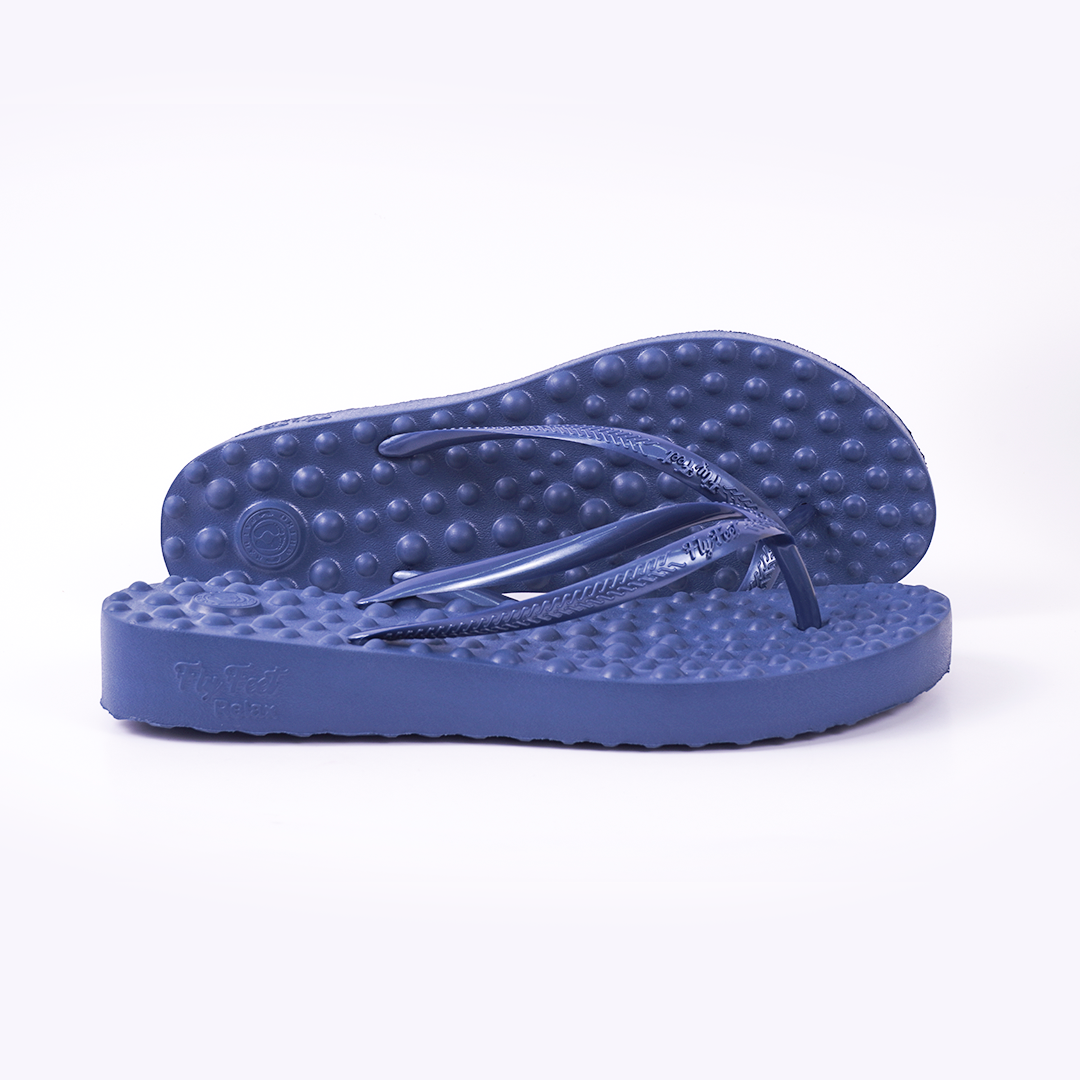 Par de sandália Flyfeet Relax, cor azul, mostrando a superfície com protuberâncias em alto relevo, projetada para ativar a circulação e estimular as terminações nervosas da planta dos pés, promovendo relaxamento e alívio da dor. 