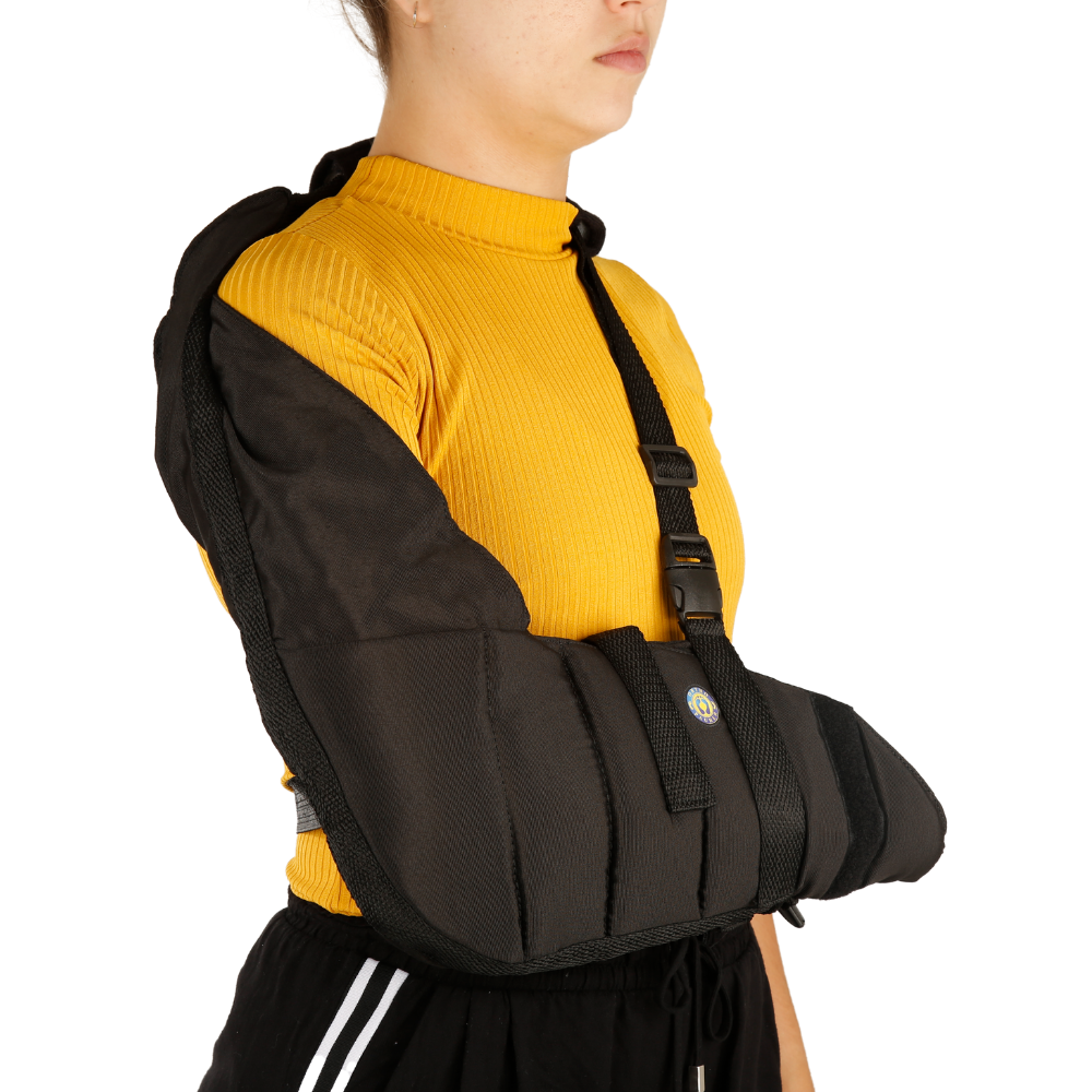 Mulher na vista lateral utilizando uma tipoia de  no braço direito, na cor preta, com a logo da Ortho Pauher na parte superiro da tipoia