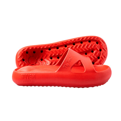 Par de sandálias ortopédicas para esporão na cor vermelha. Uma das sandálias está inclinada, exibindo a parte inferior com cavidade anatômica invertida no calcanhar. A outra está posicionada de perfil, destacando a abertura lateral para acomodação do joanete.
